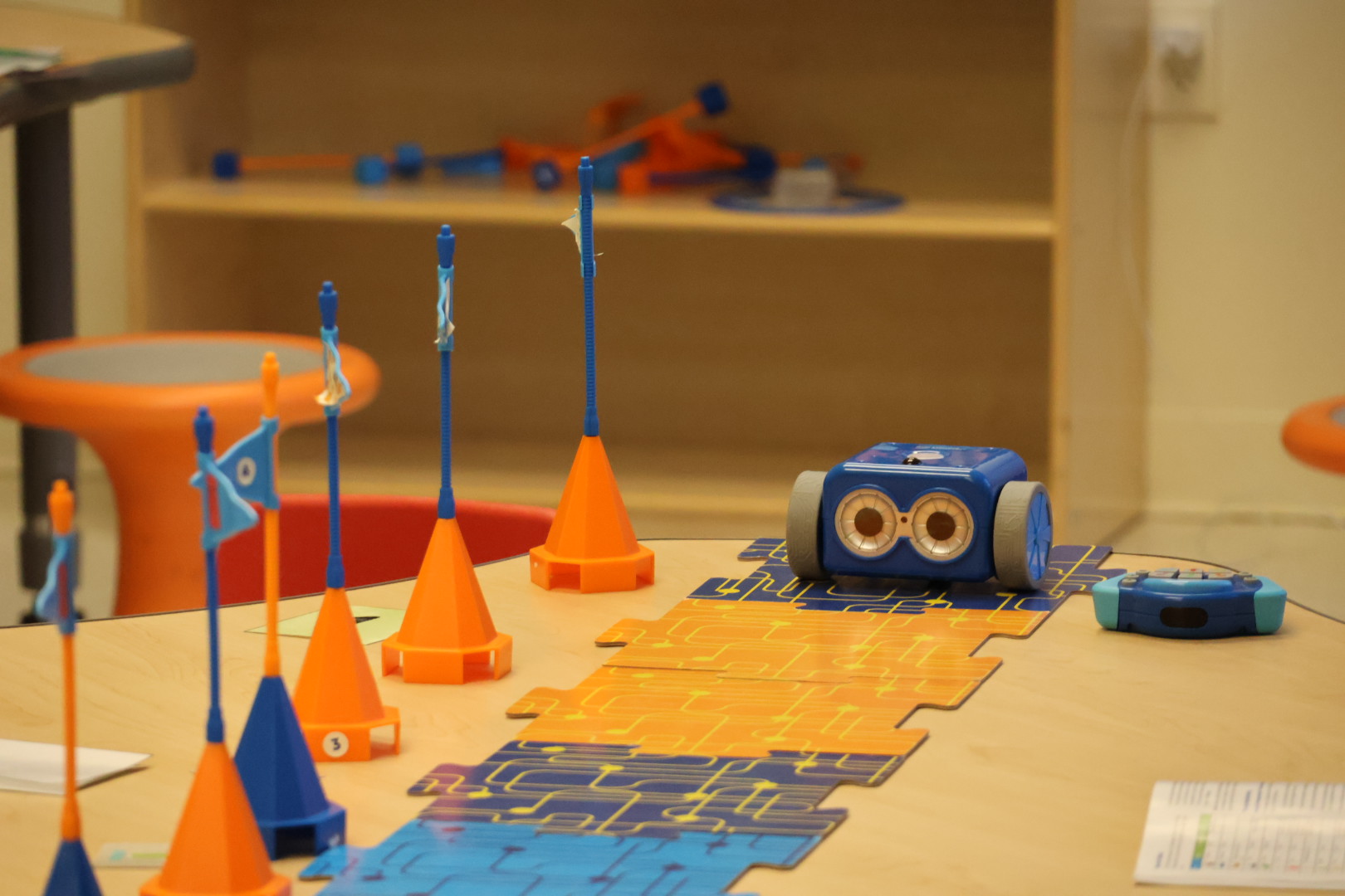 Botley robot, coding tiles, remote control, and hands-on learning materials arranged on a classroom table